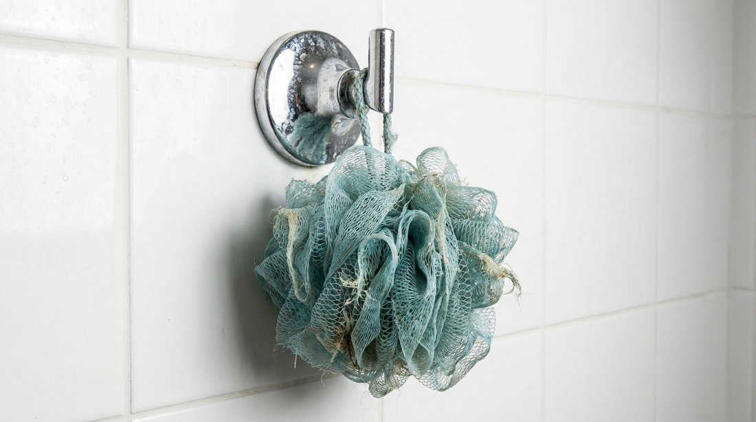 Fleur de douche en plastique usée accrochée dans une douche carrelée